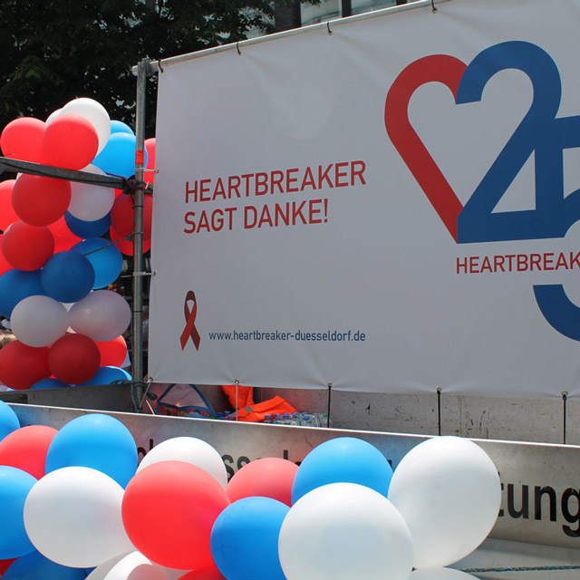 Plakat/Außenwerbung für 25 Jahre Heartbreaker. Weiße, rote und blaue Luftballons.